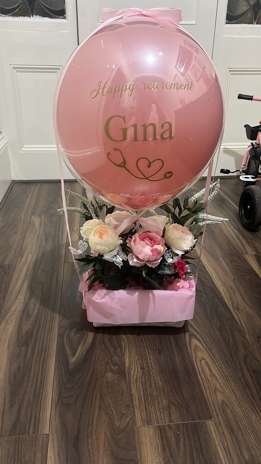A retirement gift for Gina: a pink bubble balloon over a pink box of peonies, roses and greenery
